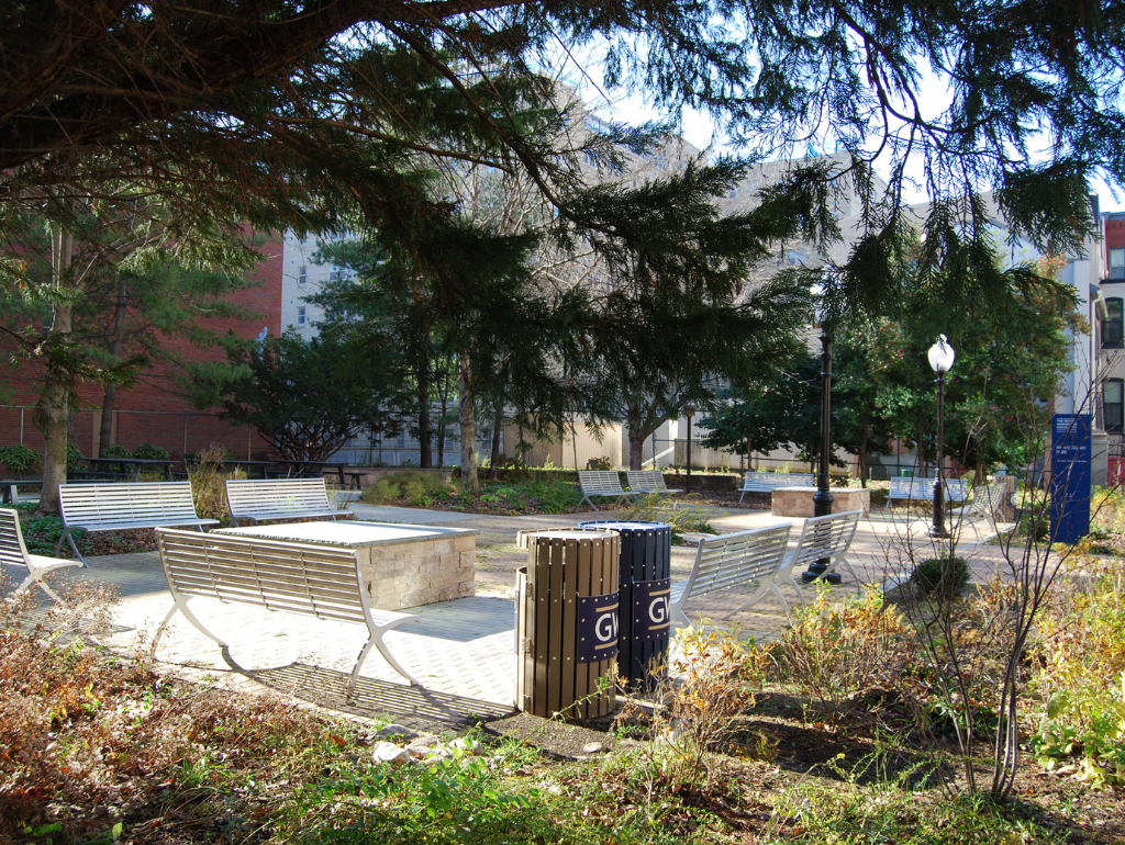 Anniversary Park with metal benches in a rectangular arrangement and trees surrounding