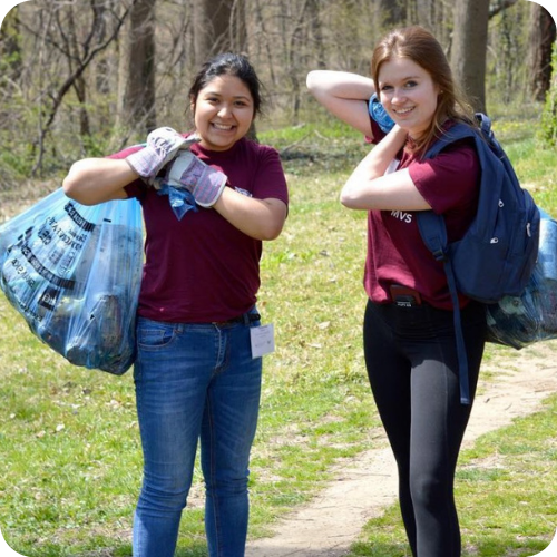 Two students volunteering and picking up litter