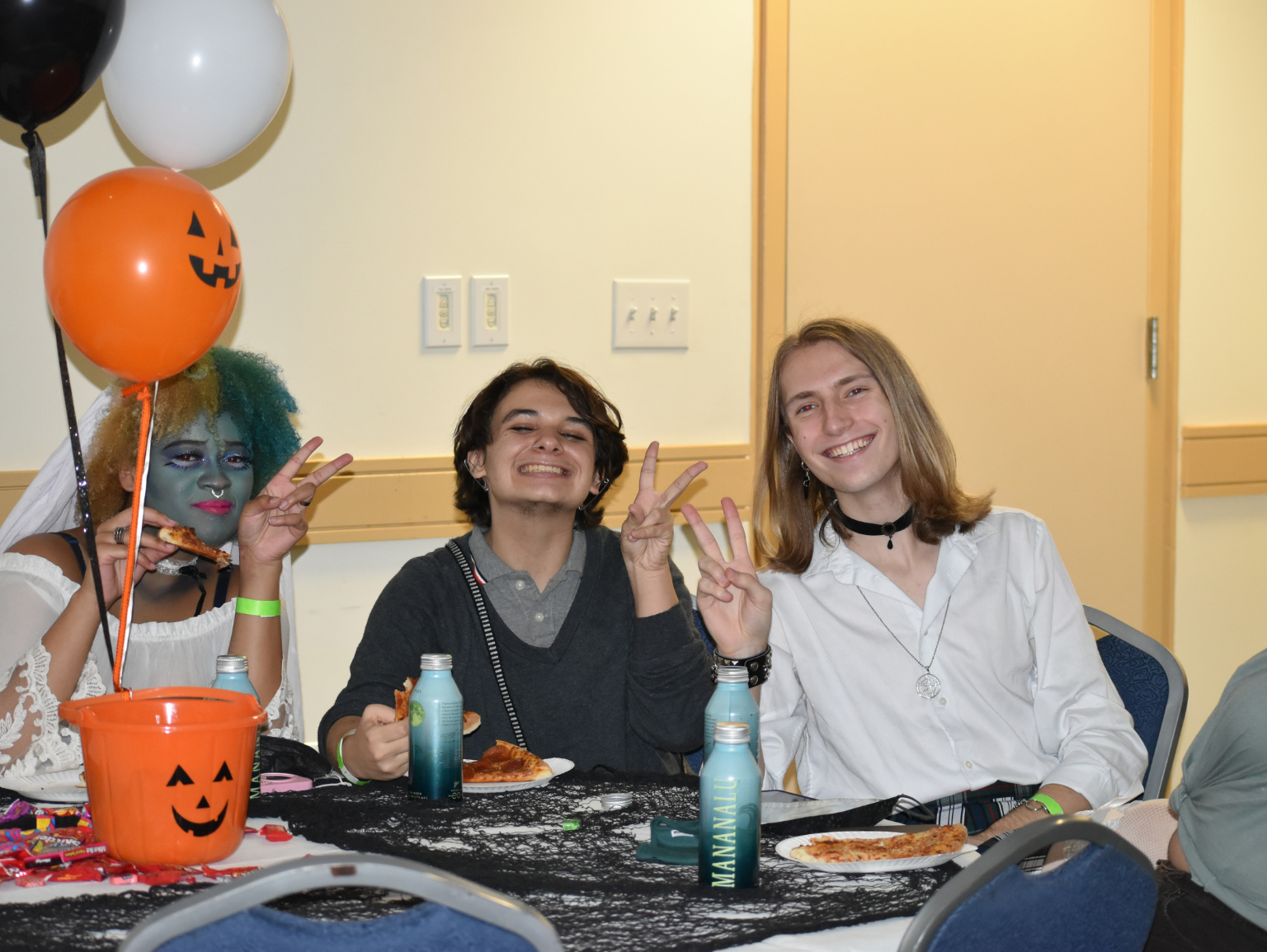 Costume-clad students enjoy pizza at the Boo Bash Halloween event in the University Student Center