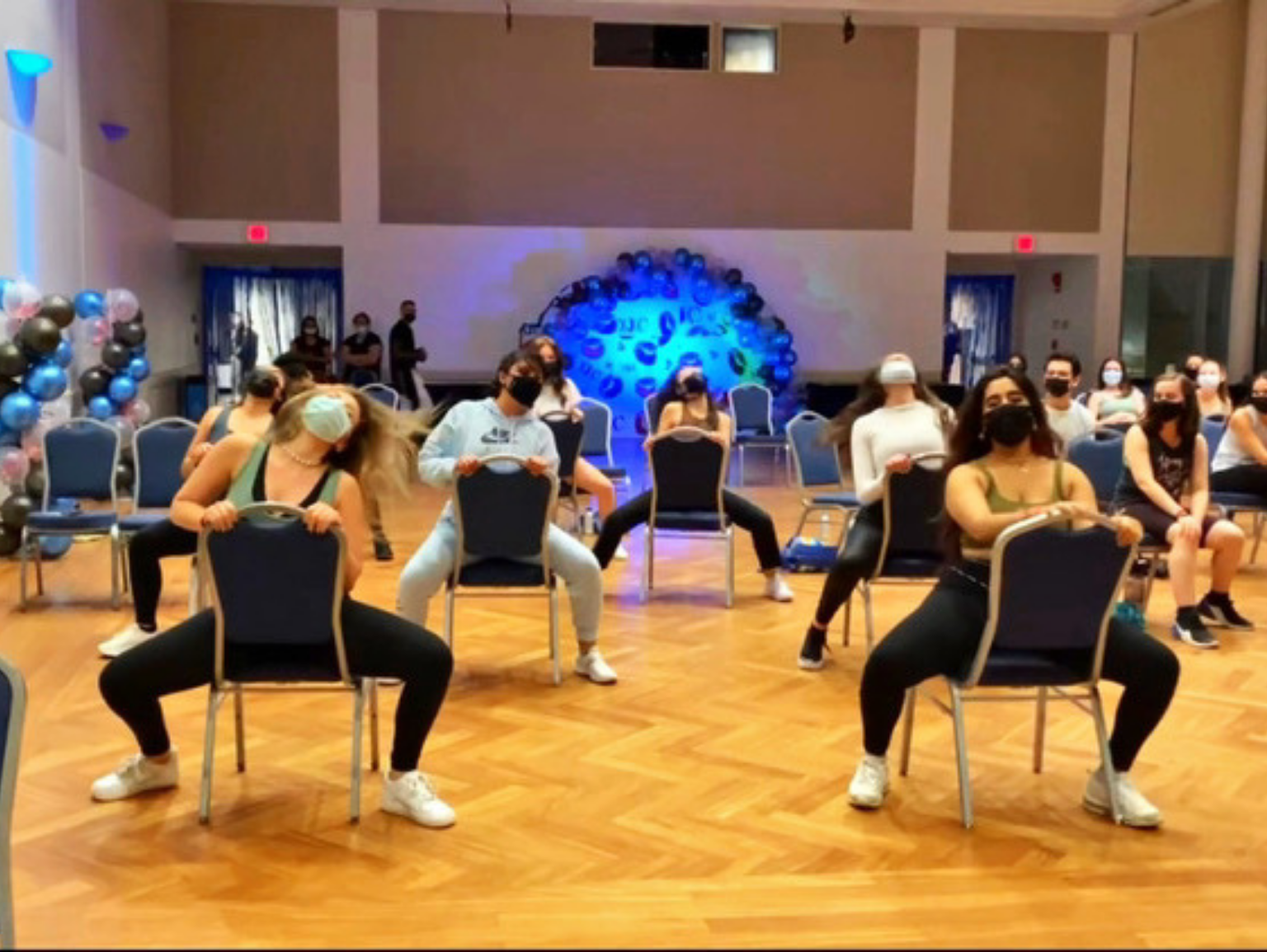Students at the chair dancing event participate in a chair dancing class led by a facilitator from Pole Pressure